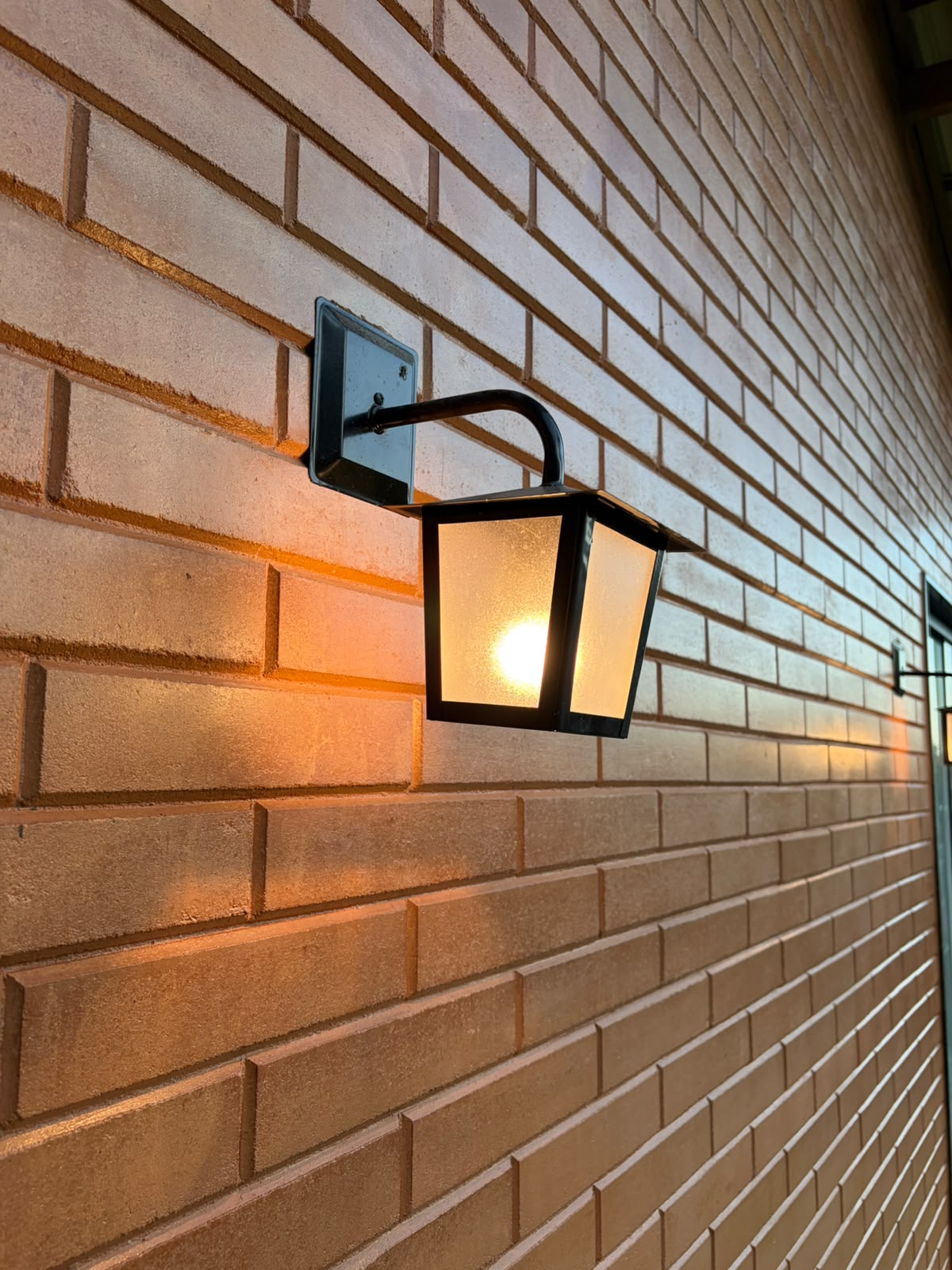 Detalhe de luminária em parede de tijolo ecológico